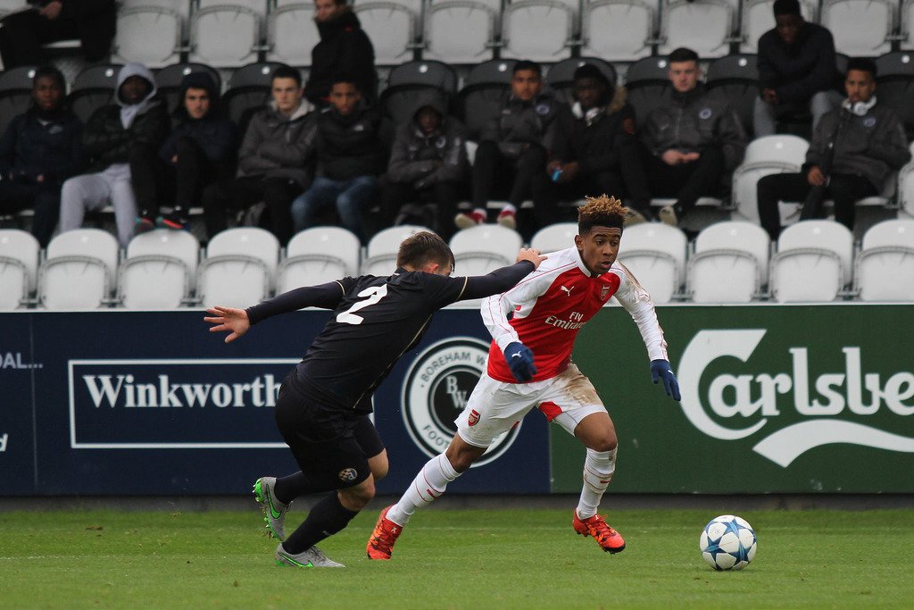  The image shows a young English footballer, Reiss Nelson, who debuted for the national team in 2016, playing a match.